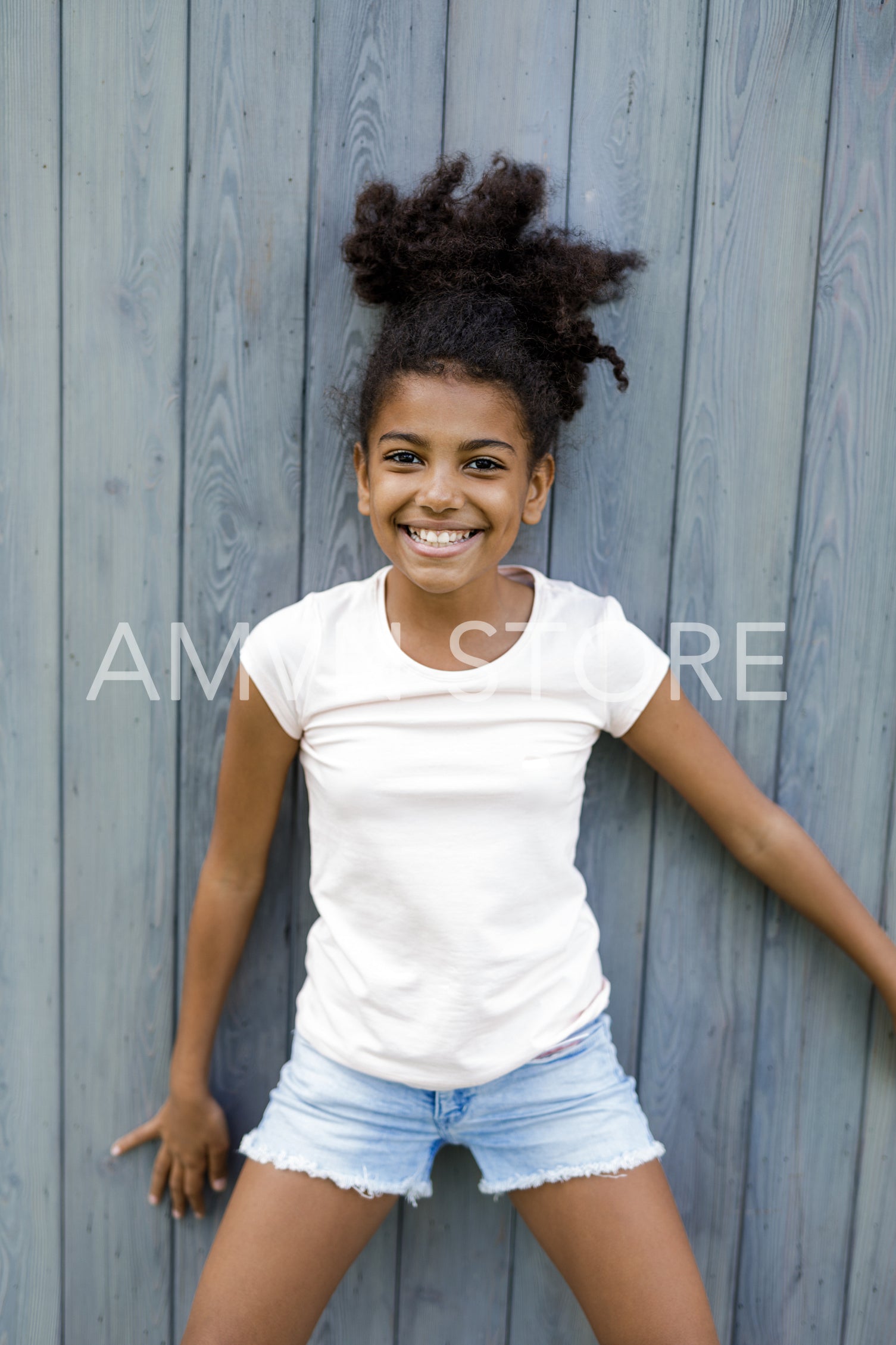 Portrait of a laughing girl standing at wall	