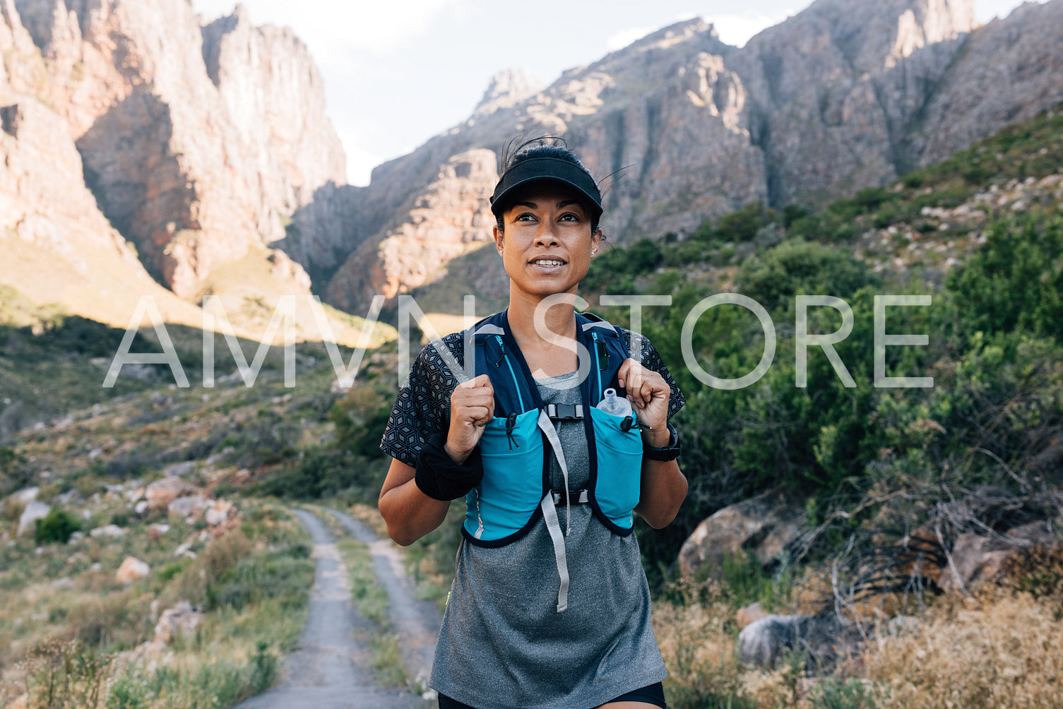 Woman in sportswear walking on abandoned road in valley