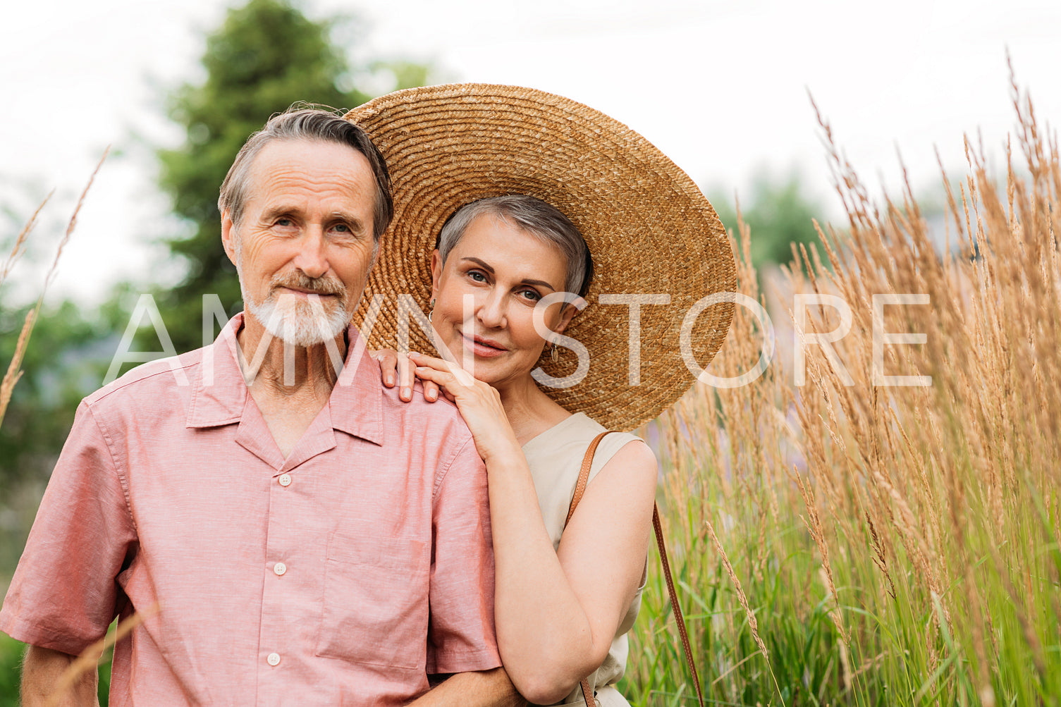 Portrait of an aged people standing together on the field. Mature husband and wife looking at the camera.