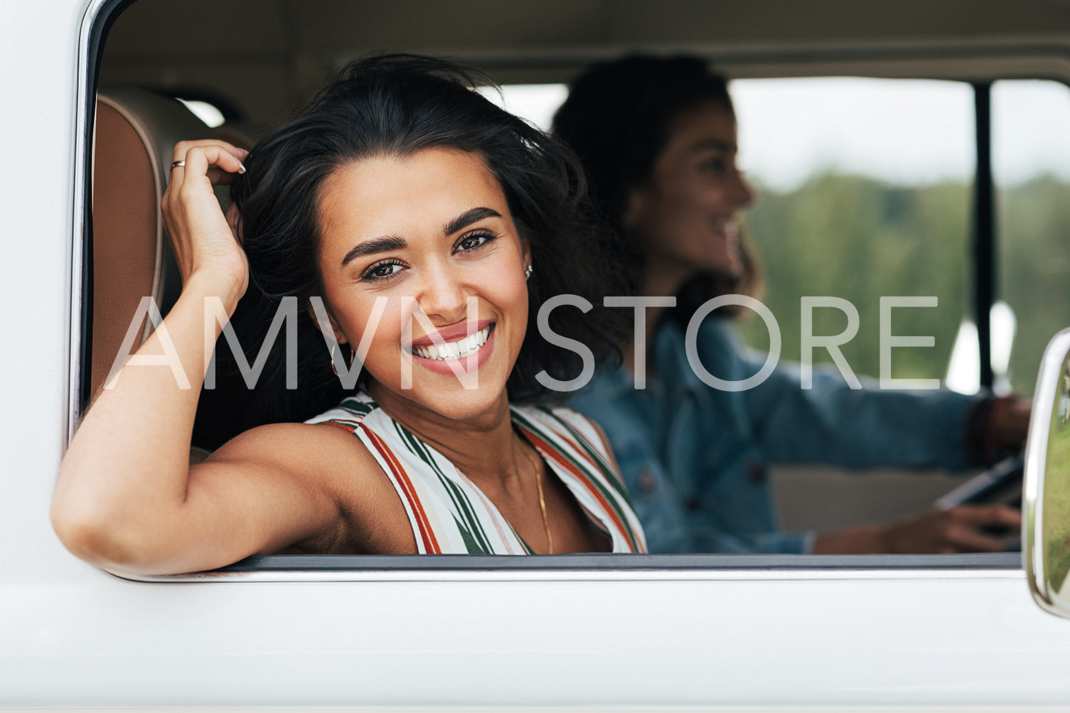 Happy woman sitting on a passenger seat in minivan and looking at camera 