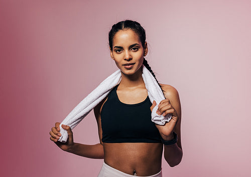 Portrait of a young sportswoman posing in studio with white towel