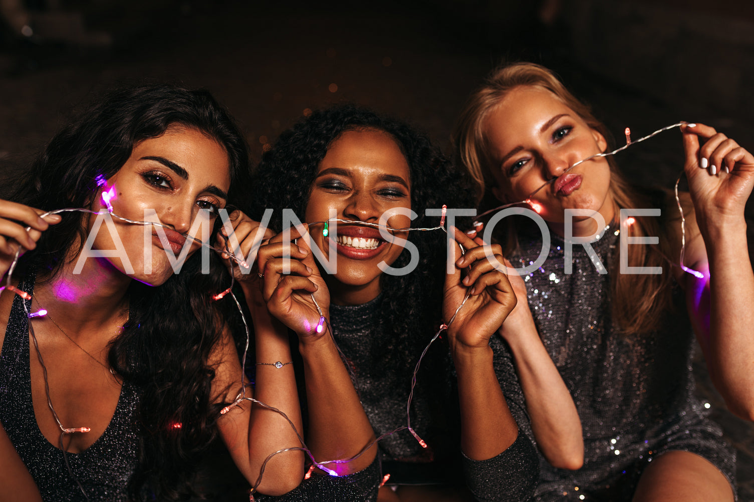 Happy friends making mustaches with christmas lights	