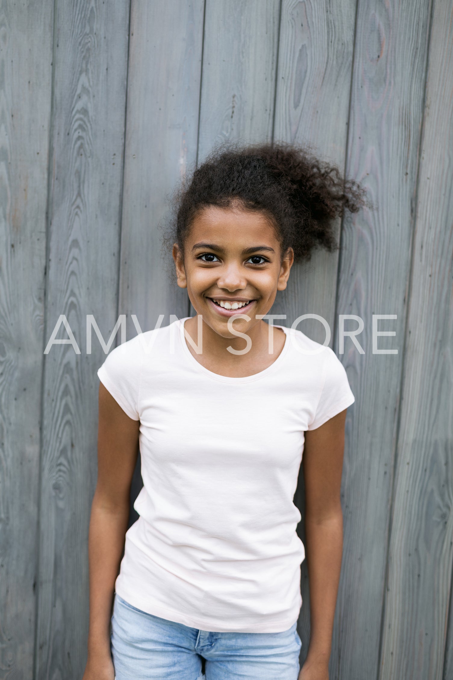 Portrait of a little smiling girl outdoors, looking at camera	