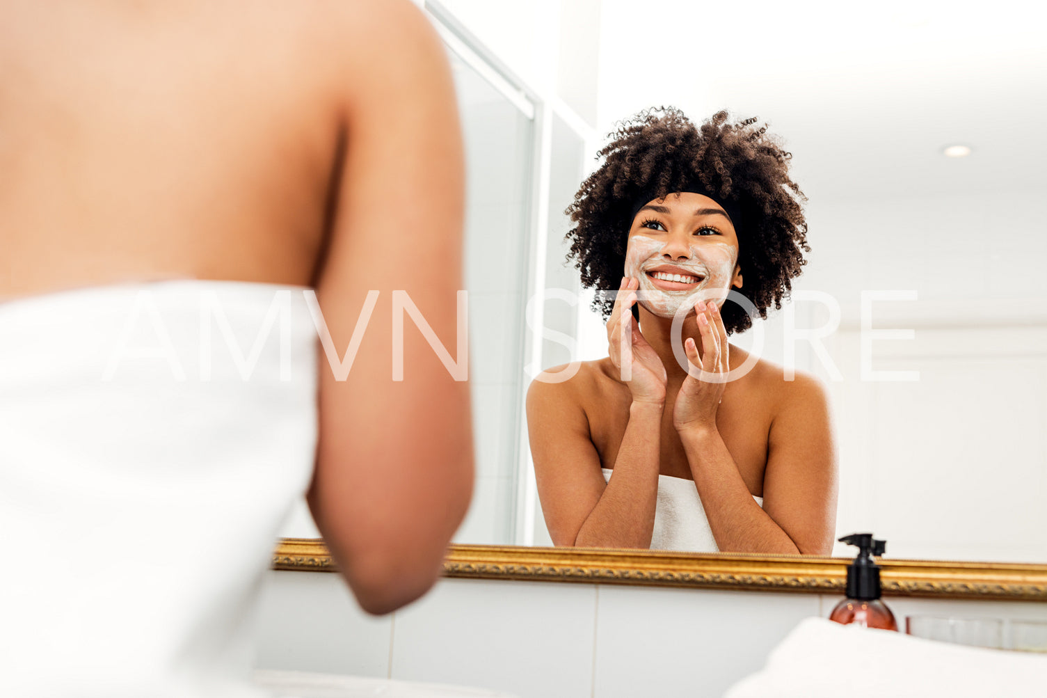 Smiling woman applying natural cream on her face