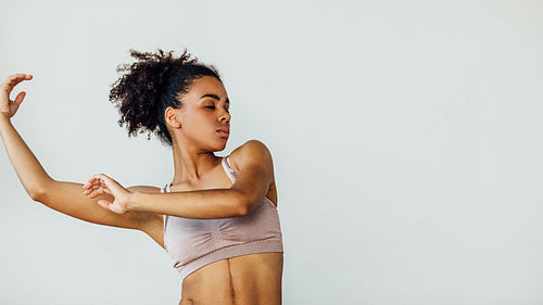 Young woman practicing dancing moves with hands in the studio