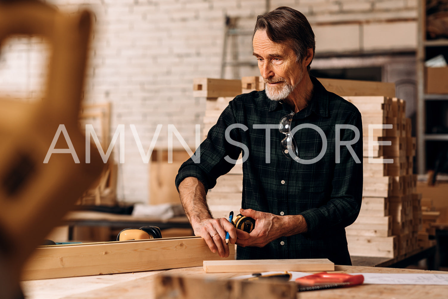 Carpenter measuring piece of wood in workshop	