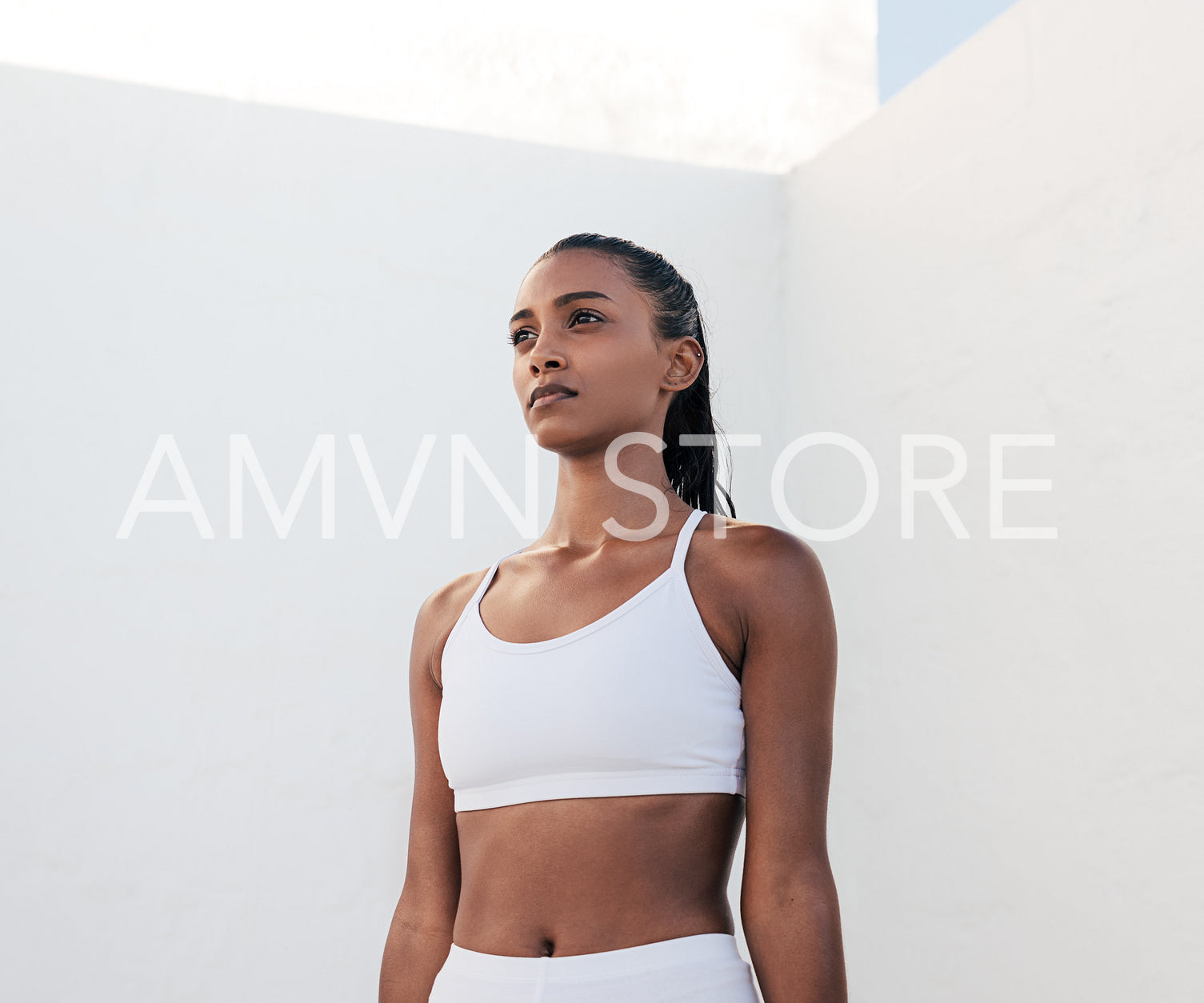 Slim confident sportswoman relaxing during exercises. Portrait of a fit female in white fitness attire.