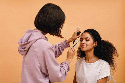 Professional stylist corrects makeup during photo shoot