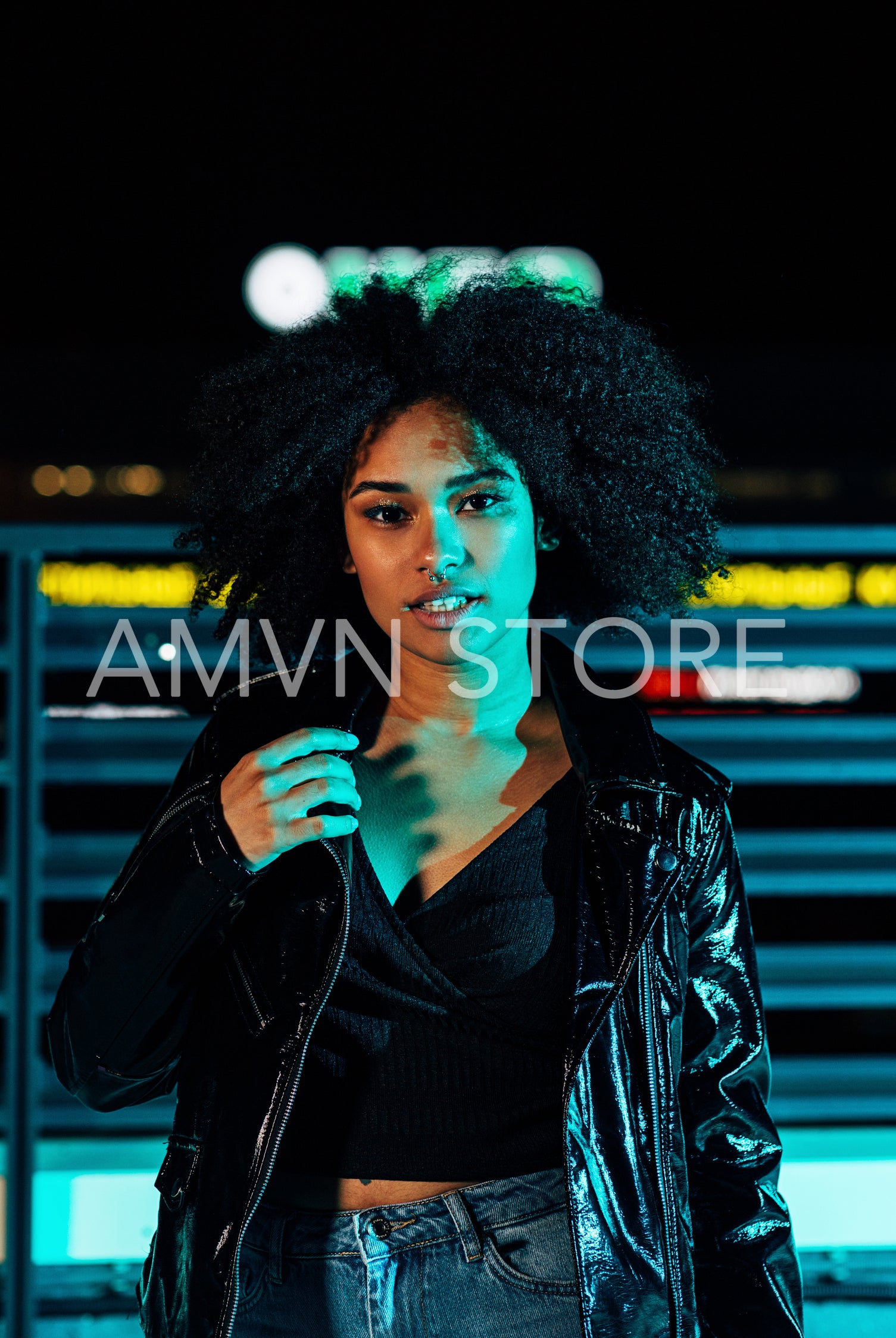 Young girl in leather jacket posing at night under neon lights	