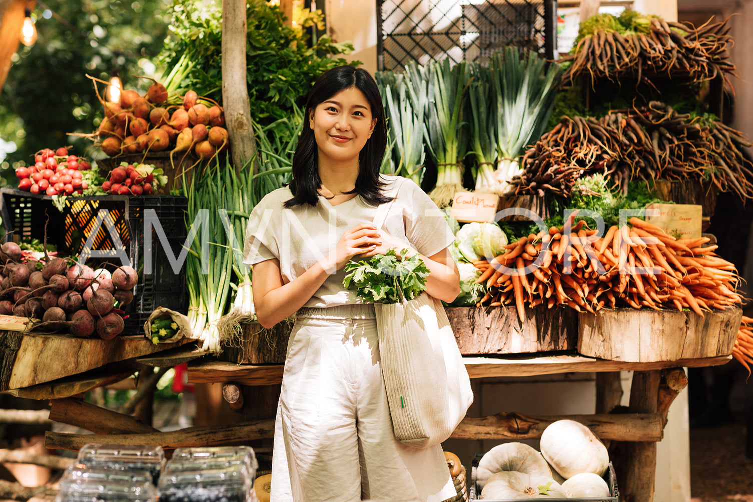 Young woman with a shopping bag on an outdoor market. Female customer on a local market.