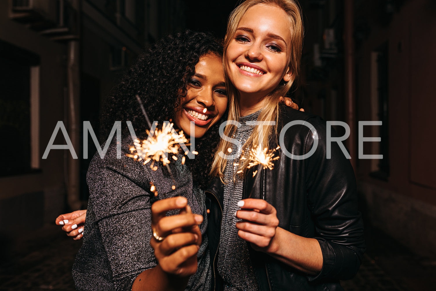 Best friends hugging outdoors with sparklers in their hands	