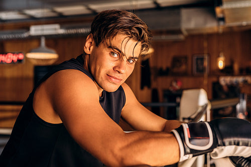 Young boxer resting after intense training in gym