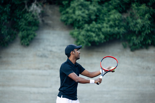 Side view of a tennis player playing on an outdoors court