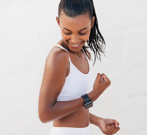 Young slim athlete flexing her hand and showing bicep after exercises