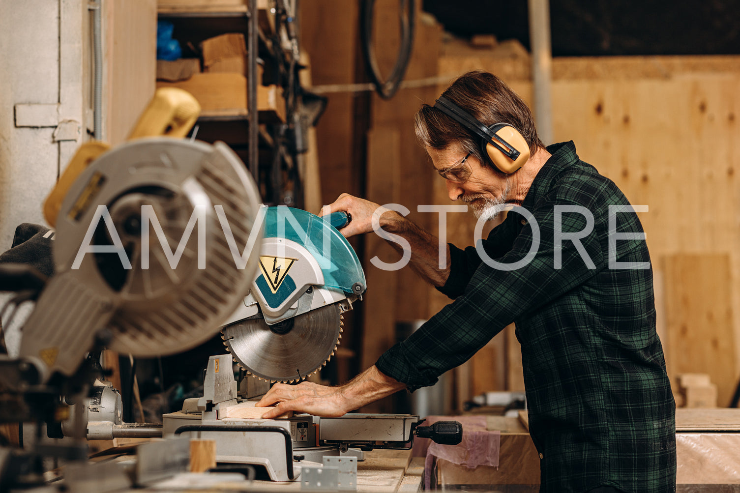 Side view of craftsperson using circular saw over wooden plank at workshop	