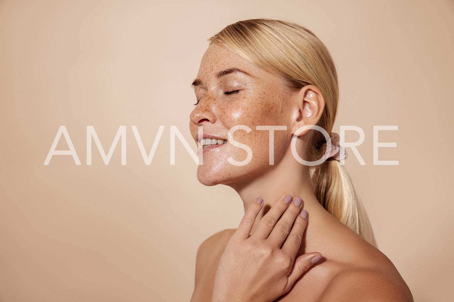 Side view of smiling woman with freckles standing with closed ey