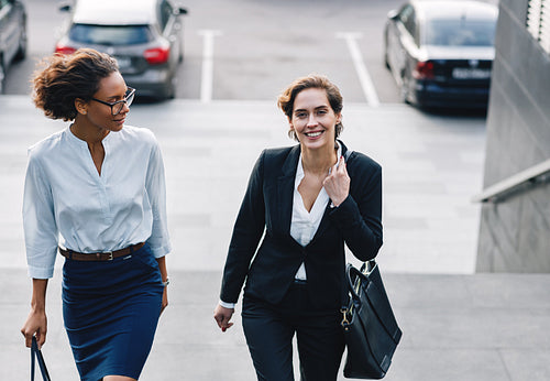 Two business people walking up the steps outdoors