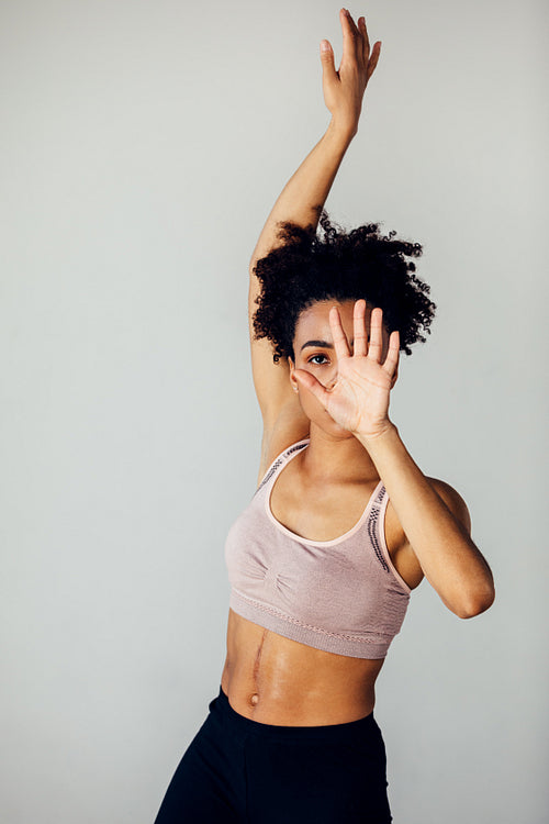 Young dancer hiding her face with hand in a small studio