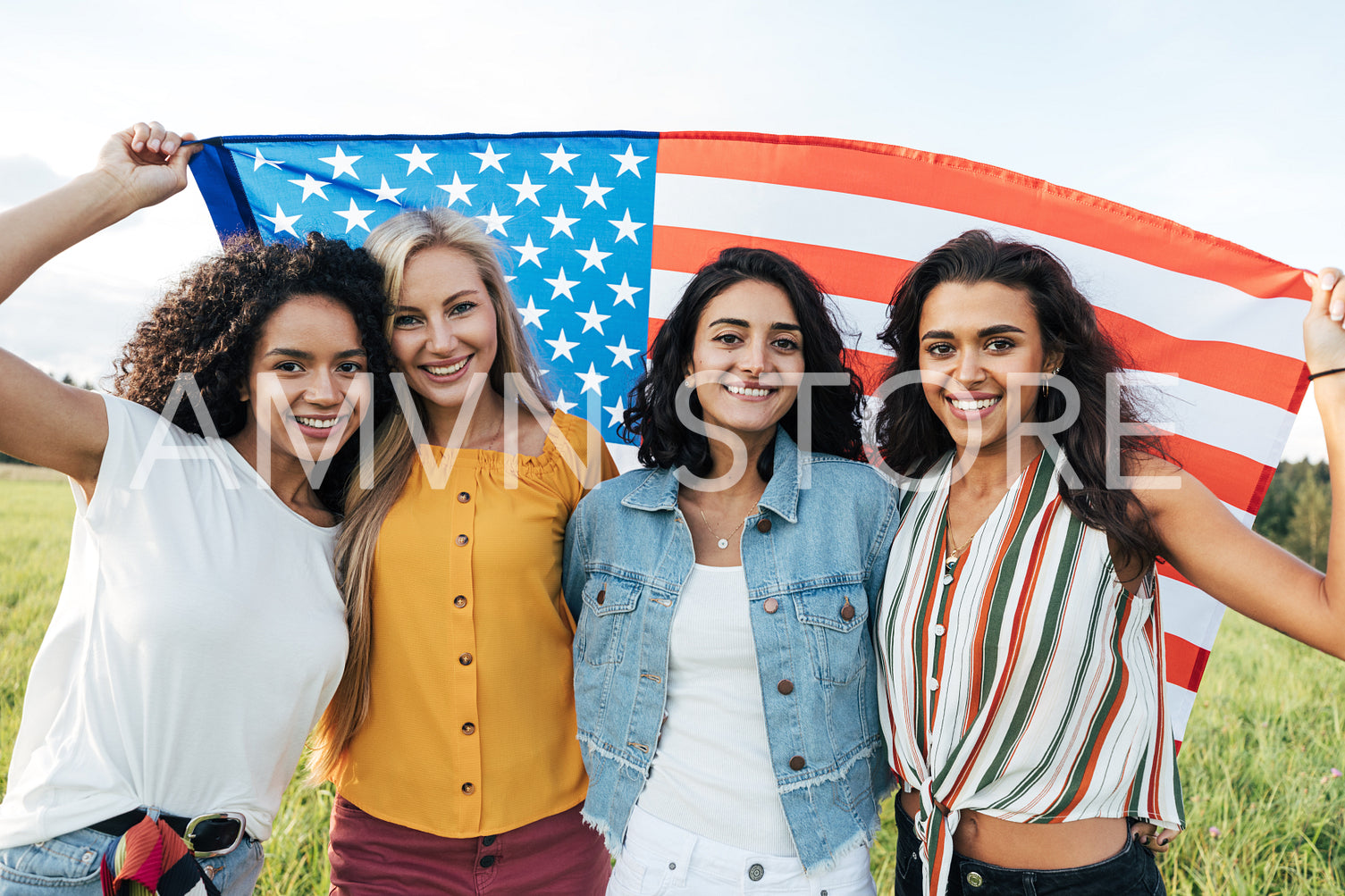 Group of multi-ethnic women holding a USA flag. Female friends celebrating independence day.