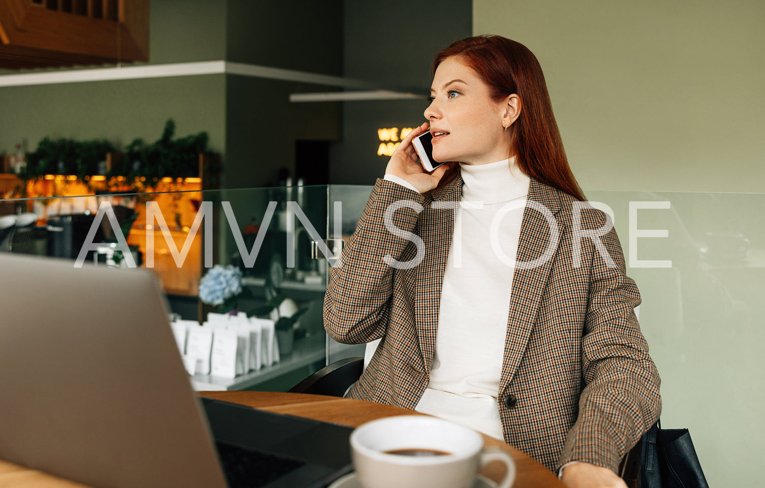 Businesswoman in formal wear talking on mobile phone while sitting in cafe