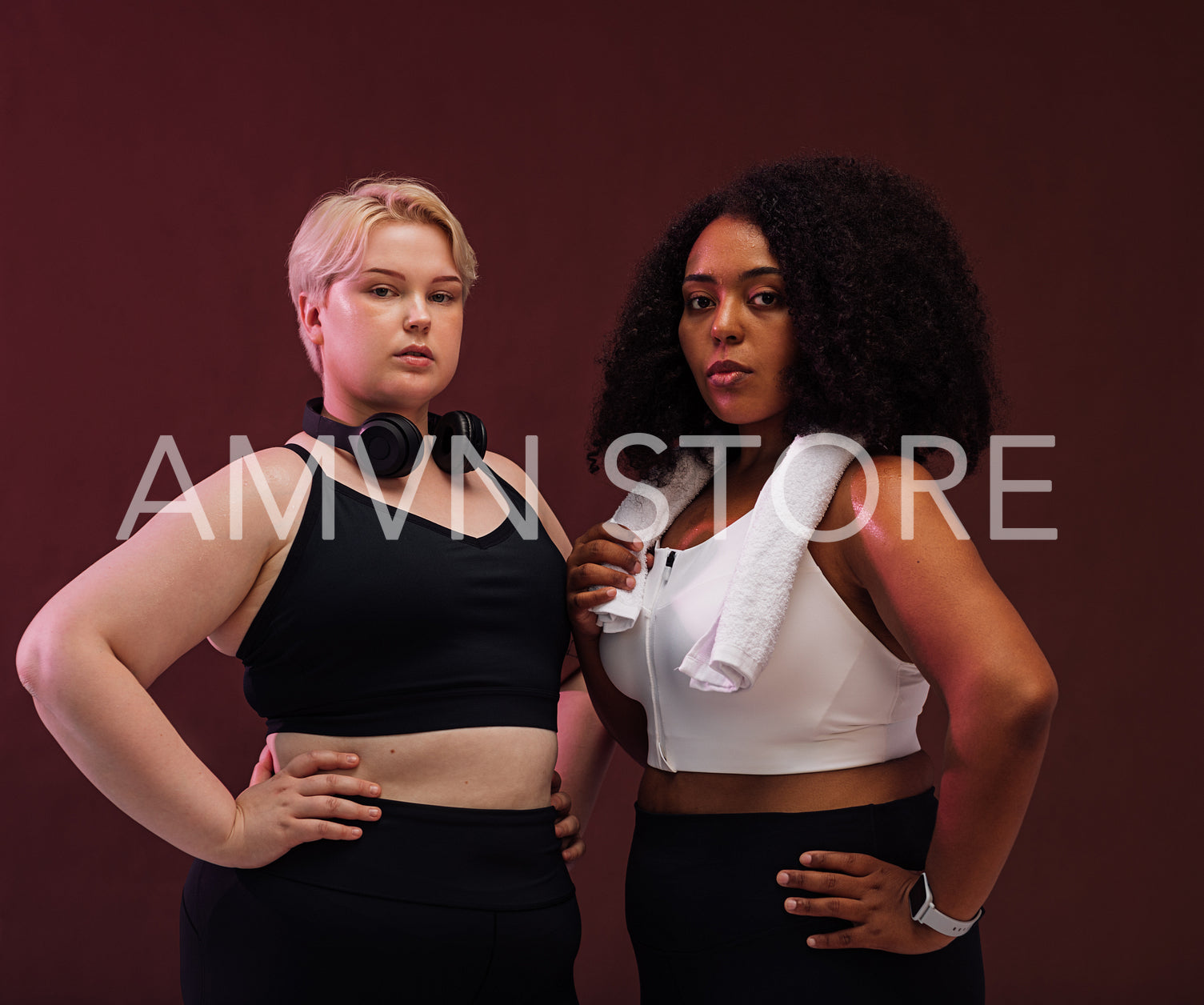 Confident females with plus size bodies standing together in studio and looking at camera