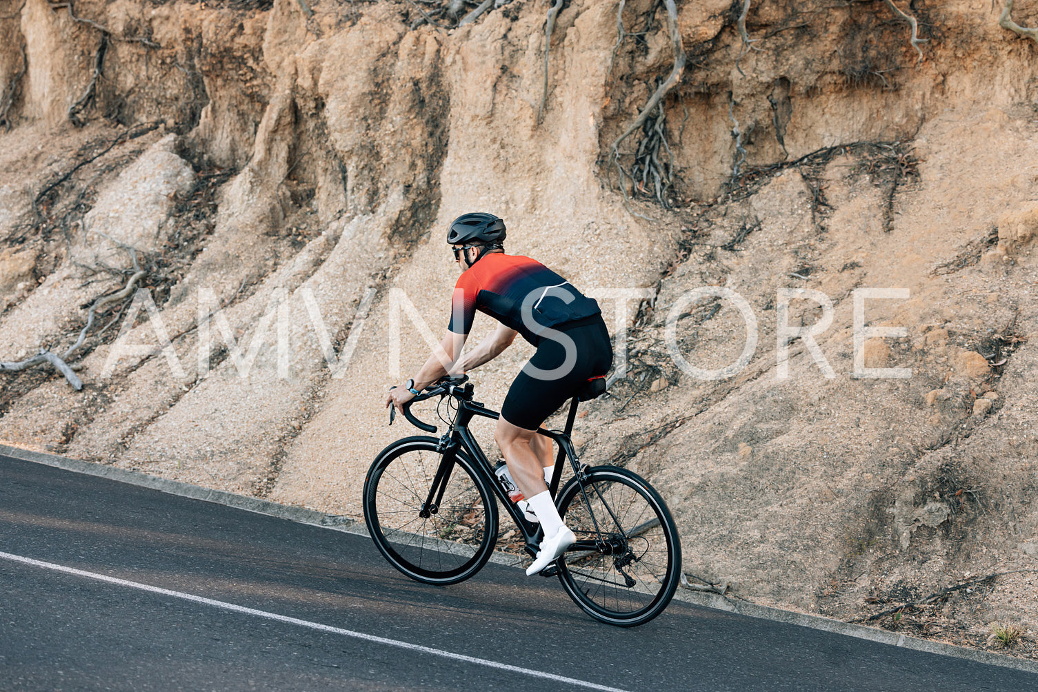 Male cyclist practicing on his road bike at a hill