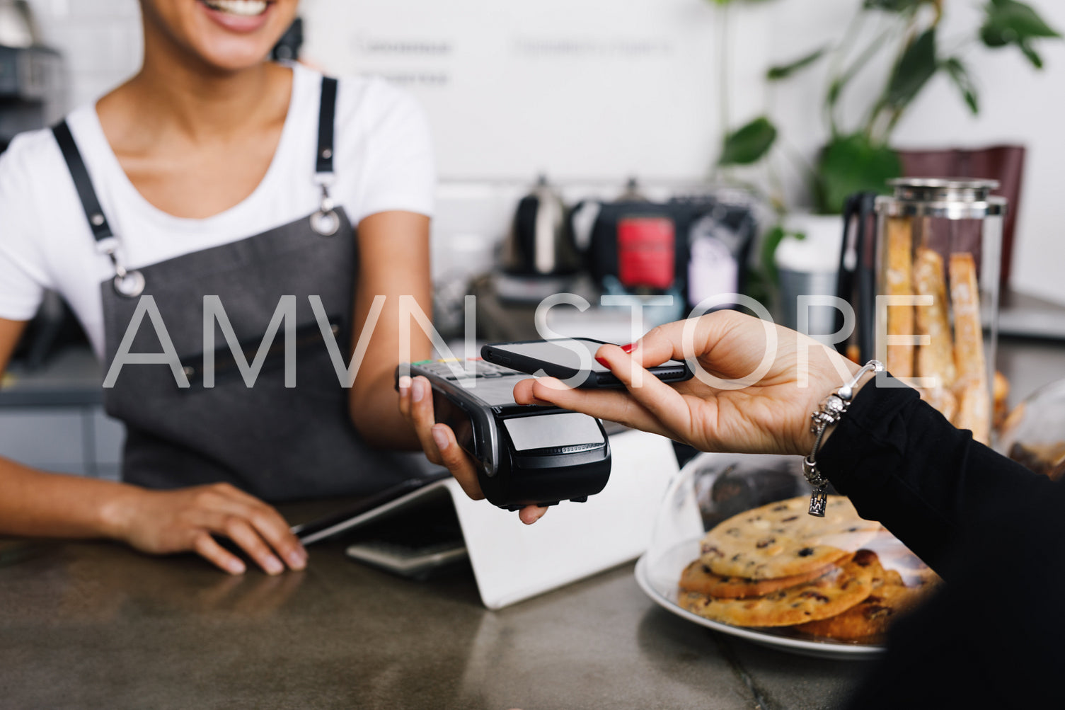 Customer making wireless payment using smartphone in cafe	