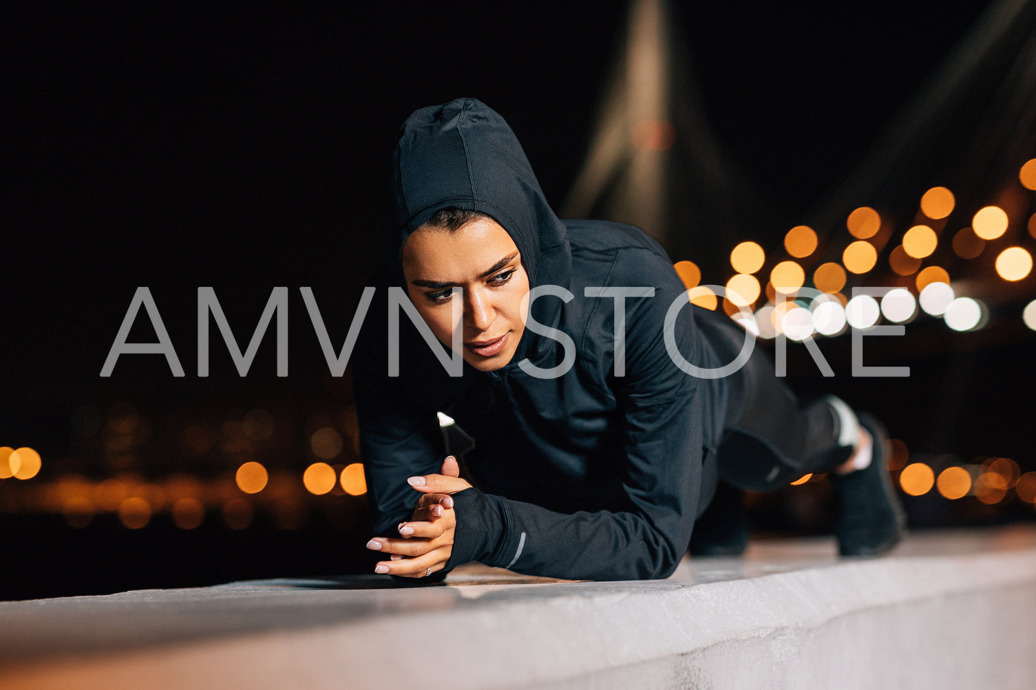 Young athlete doing plank position while exercising outdoors at evening