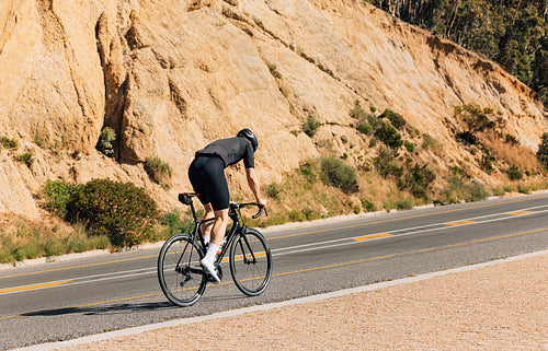 Male cyclist riding on an empty road. Professional cyclist exercising on a road bike.