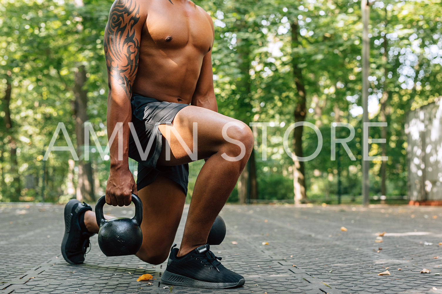 Cropped shot of young sportsman exercising with kettlebells outdoors	