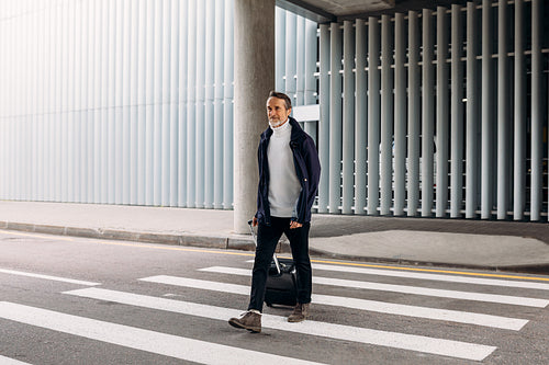 Man with suitcase walking outside an airport terminal