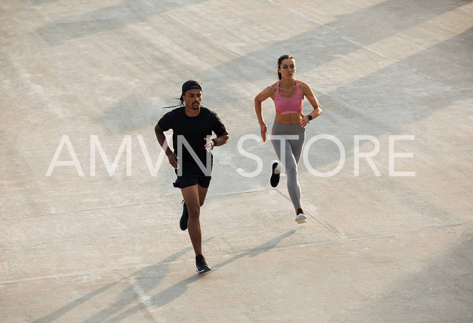 High angle of man and woman running together on rooftop at sunset