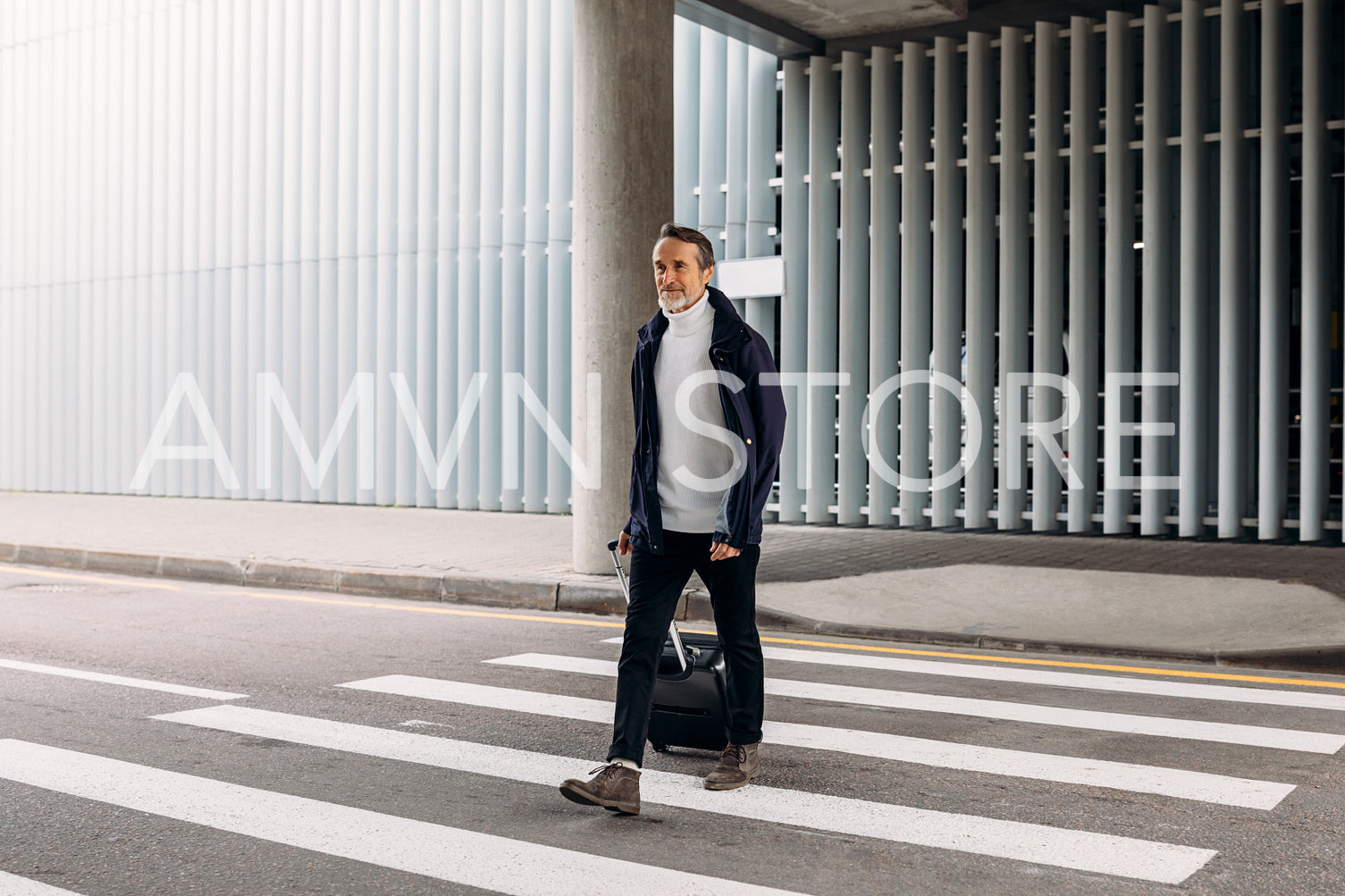 Man with suitcase walking outside an airport terminal	