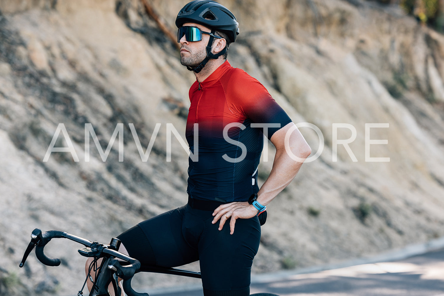 Male cyclist in sportswear standing on a road with bicycle relaxing after ride