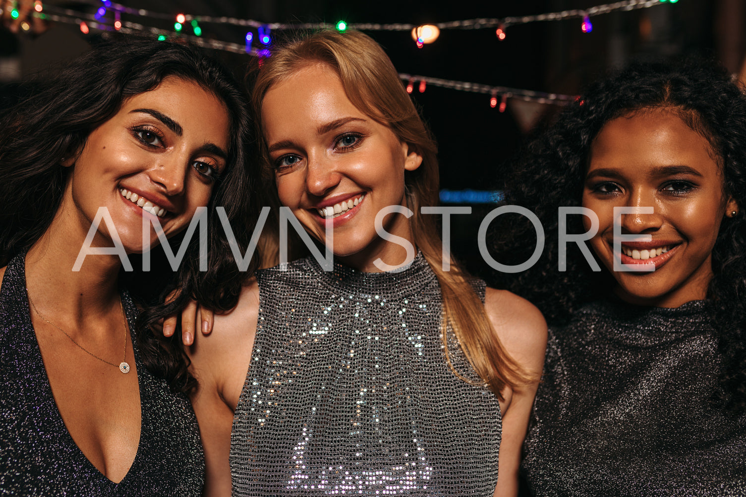 Outdoor portrait of young women standing in front of christmas light at night	