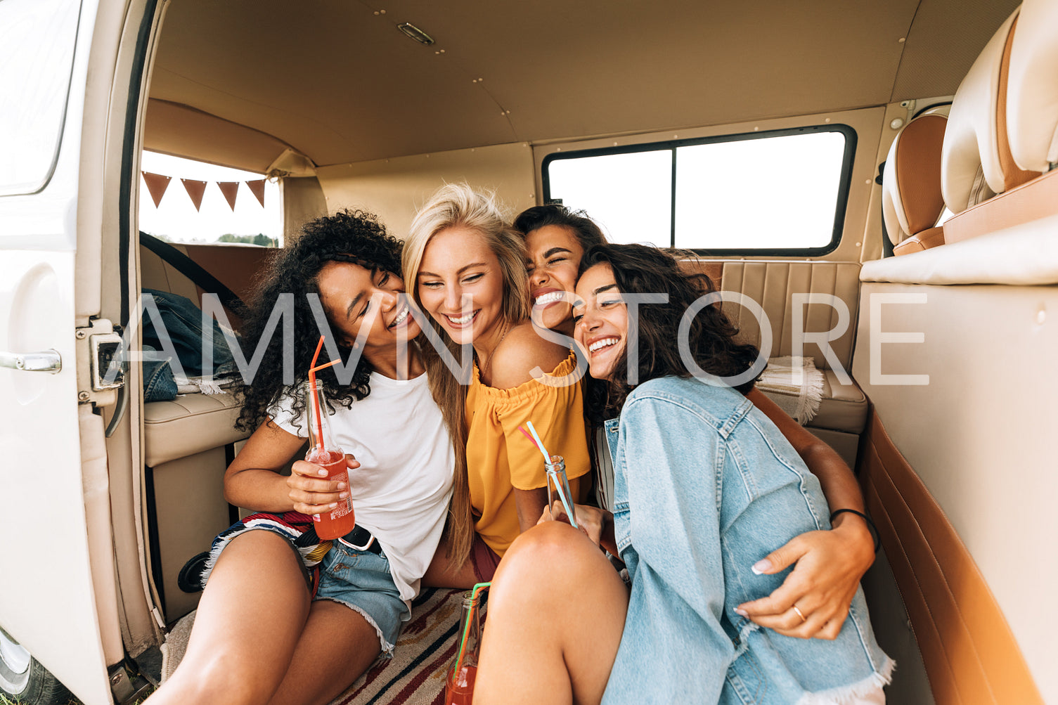 Beautiful female friends embracing each other while sitting in car