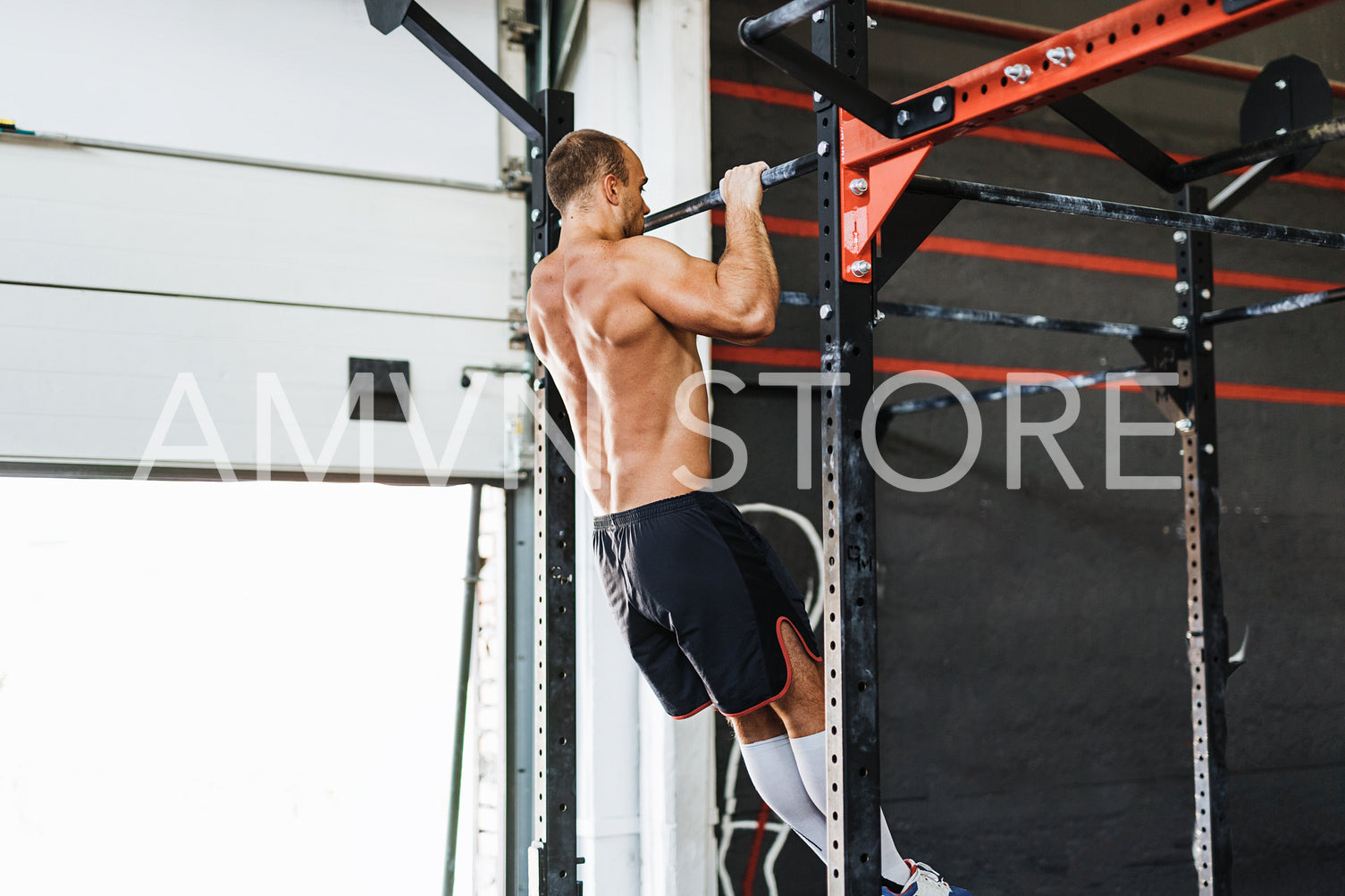 Young bodybuilder doing pull-up workout in gym	