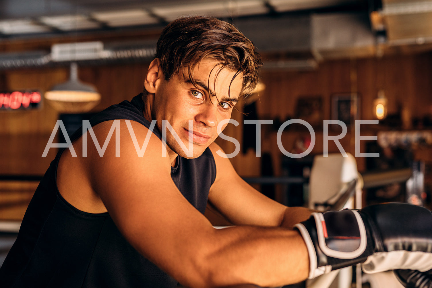 Young boxer resting after intense training in gym