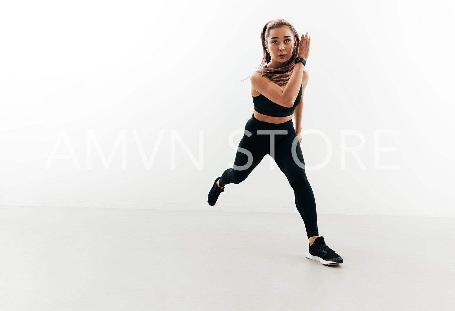 Muscular woman exercising in studio. Young female running forward.