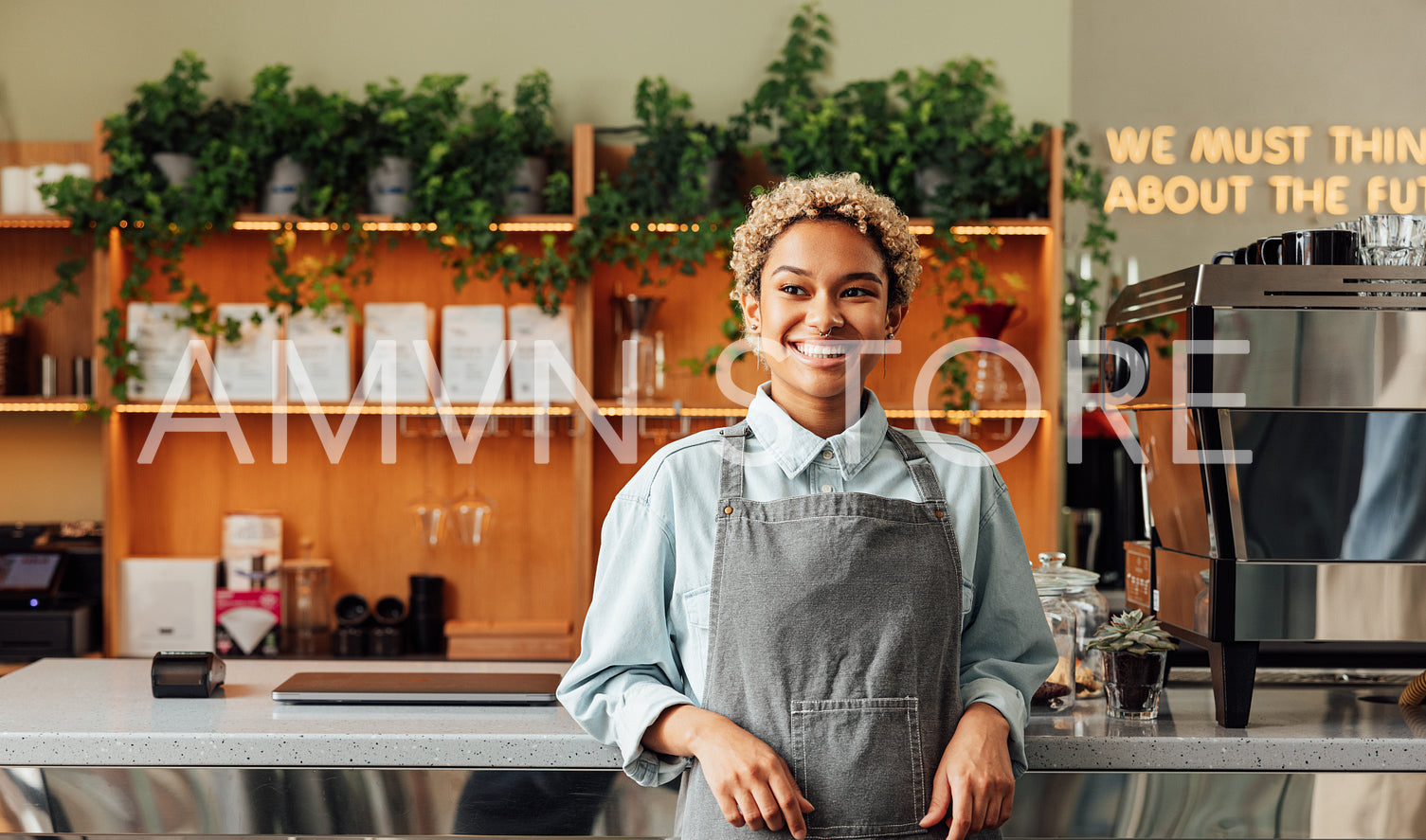 Confident coffee shop owner in an apron. Young smiling woman in an apron standing at the bar counter.