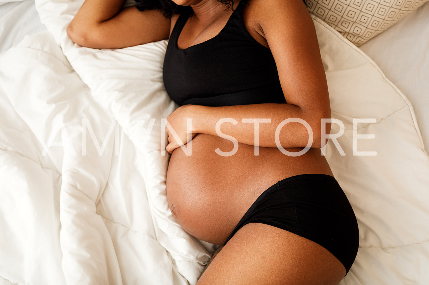 Unrecognizable pregnant woman lying on a bed	