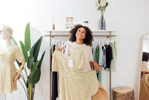 Woman buyer having fun while looking for new clothes in a boutique