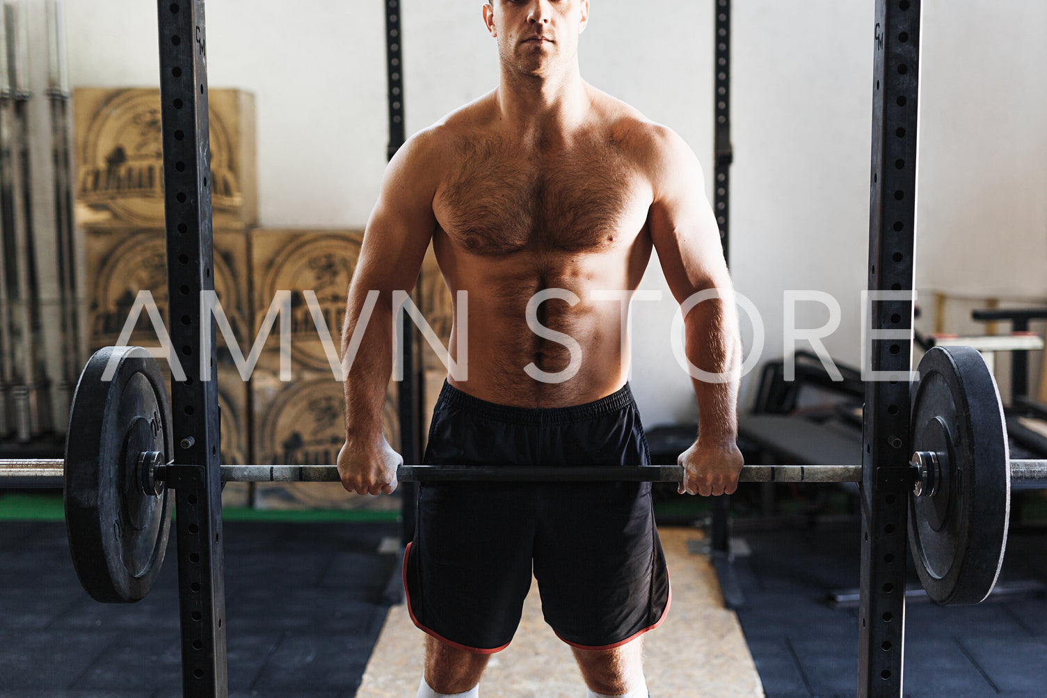 Cropped shot of young athlete at gym exercising with barbell, front view	