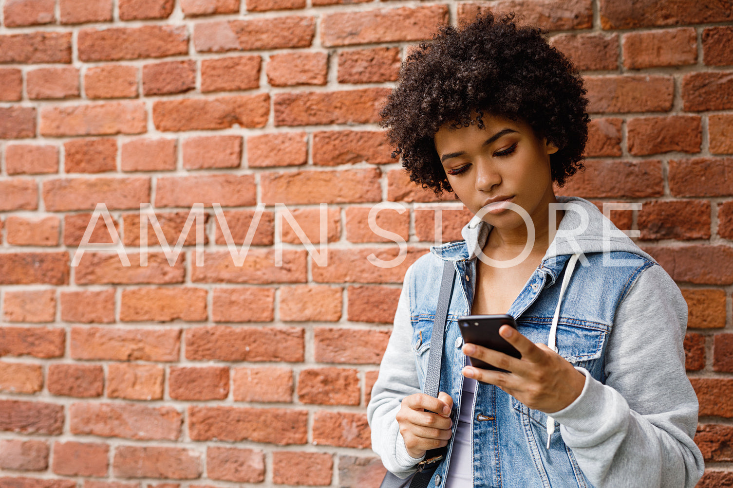 Teenage girl chatting on the mobile phone. Young woman checking social media outdoors.	