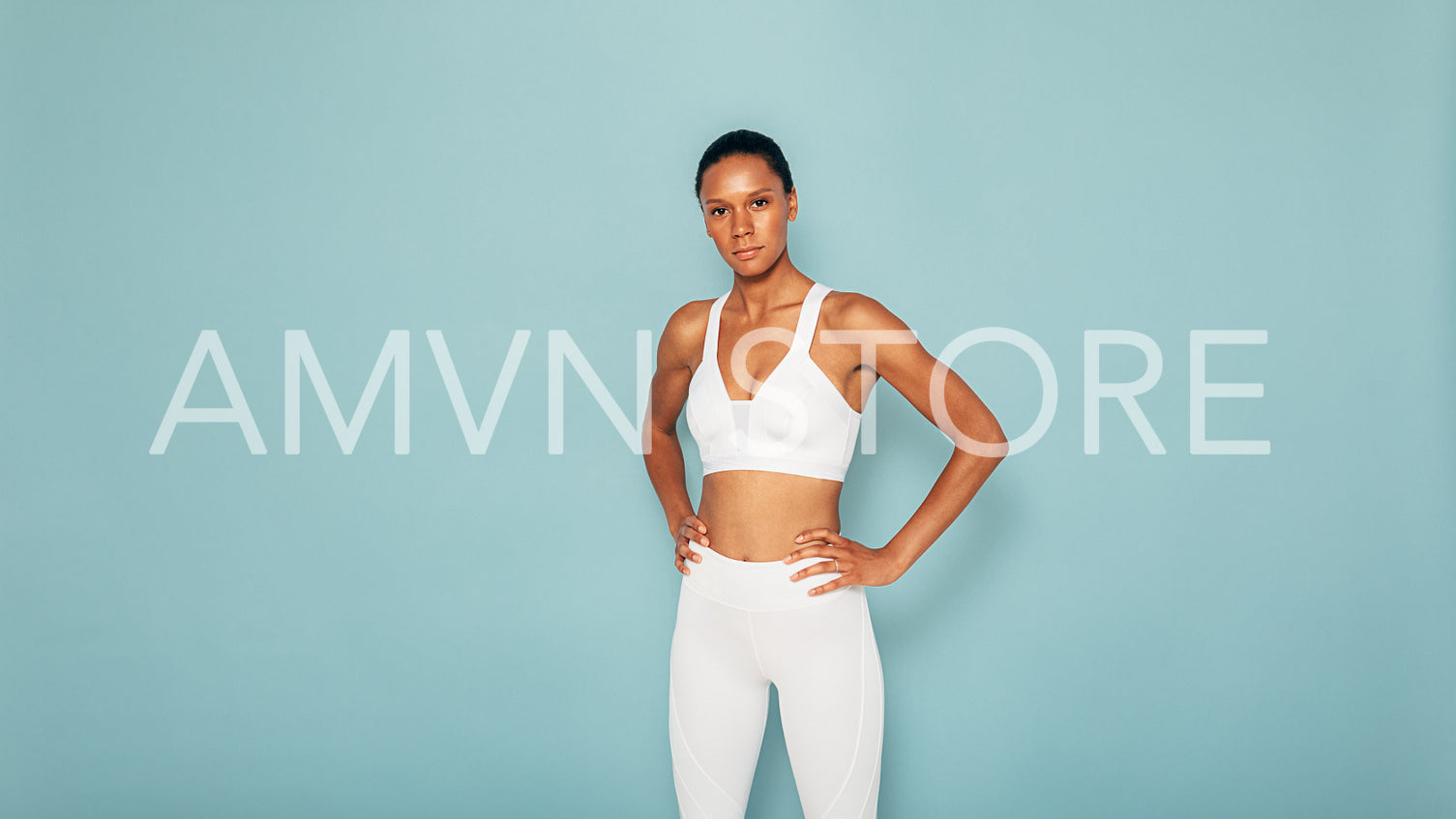 Portrait of a muscular fitness model on blue background looking at the camera	