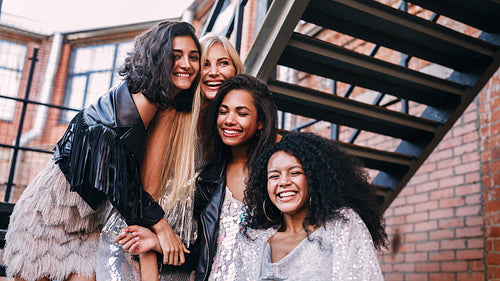 Multi-ethnic group of female friends laughing outdoors standing on the staircase