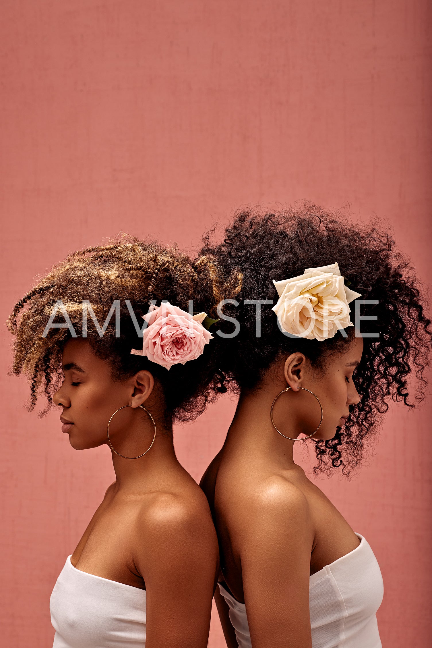 Two women with flowers in their hairs standing back to back at a