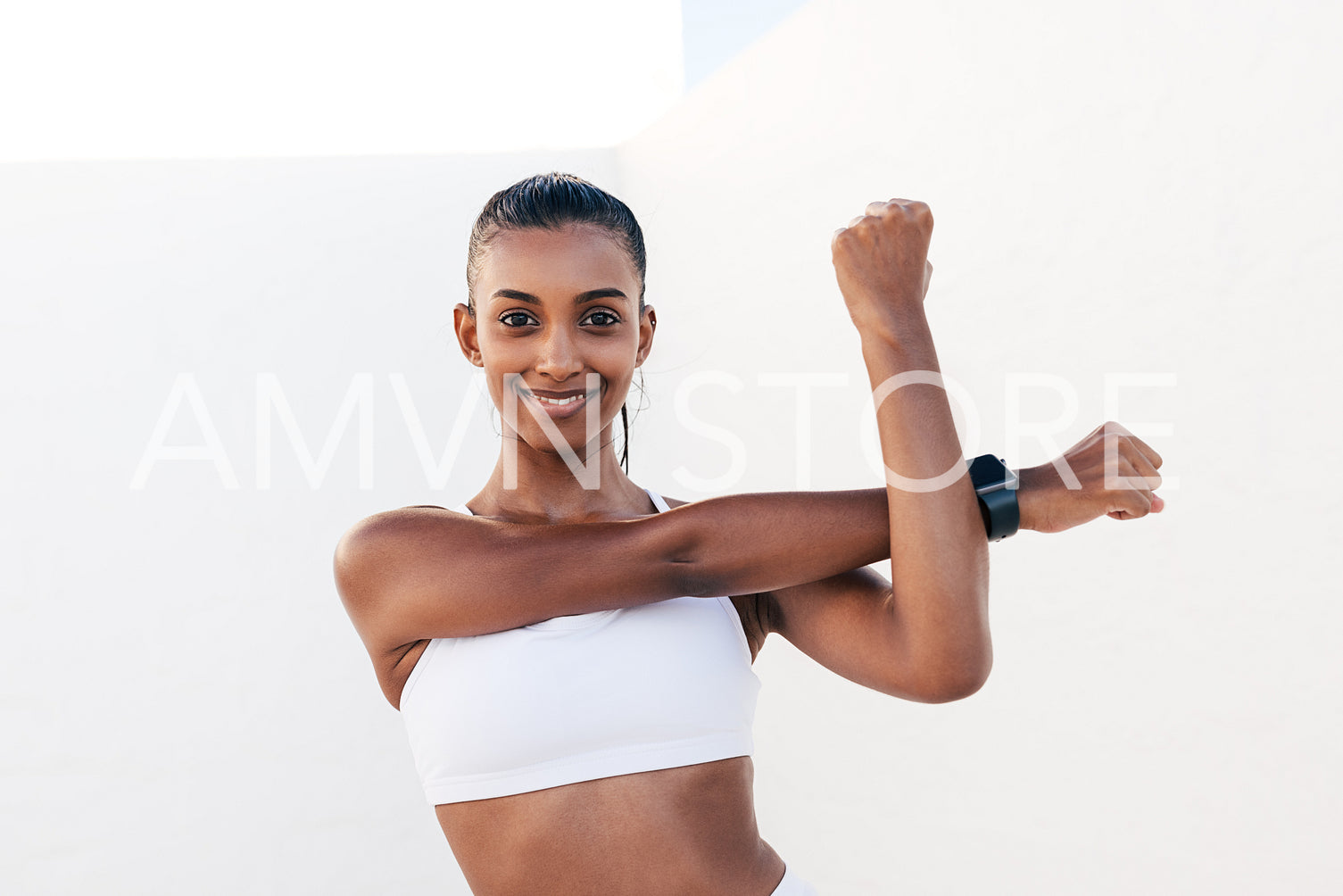 Smiling woman flexing her hands before exercises. Young slim female warming up her hands and looking at the camera.