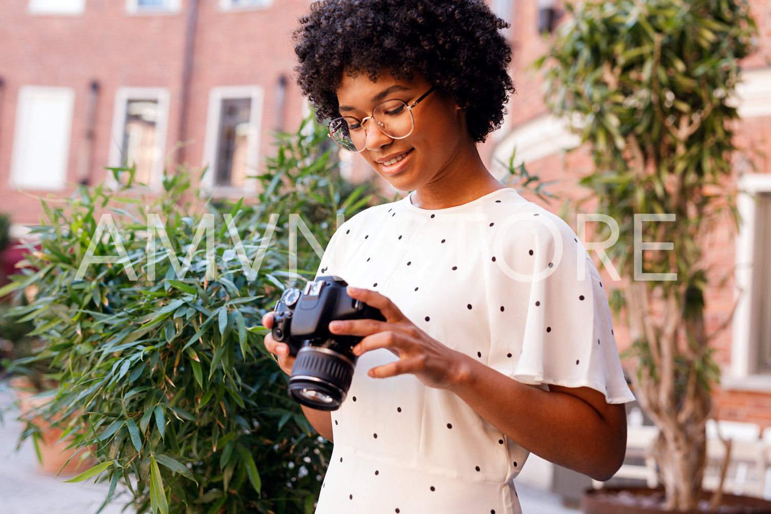 Young tourist viewing photos on digital camera while sitting outdoors	