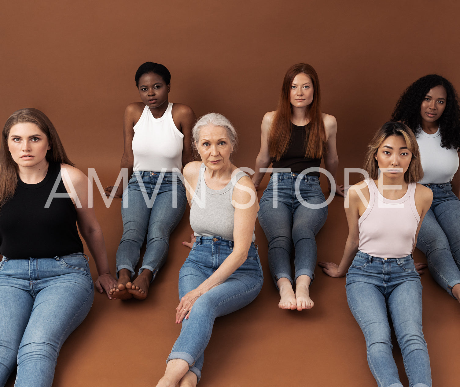 Six different females on a brown background. Group of six women with different body types and skin tones are looking at camera. Females of different ages in casuals sitting together in studio.